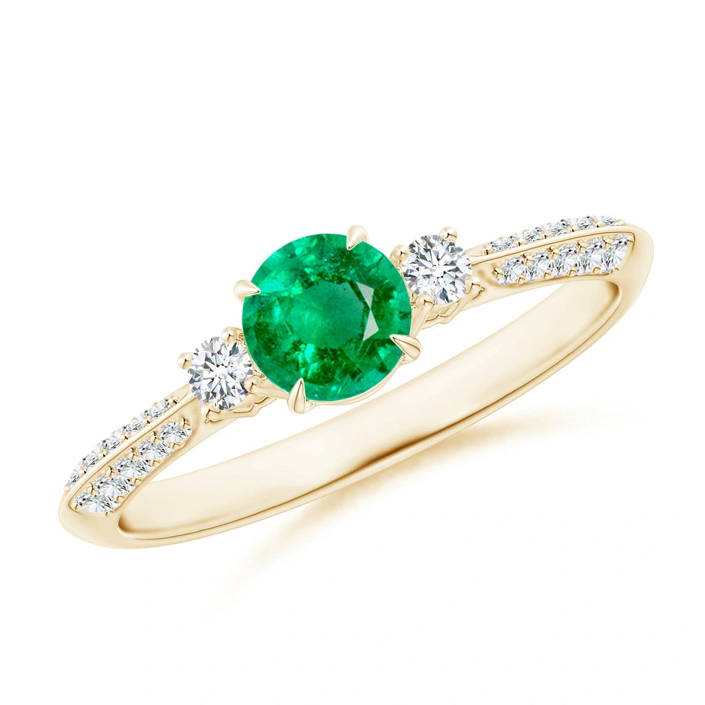 Yellow gold ring with a round green stone between two white stones, small stones set along both shoulders