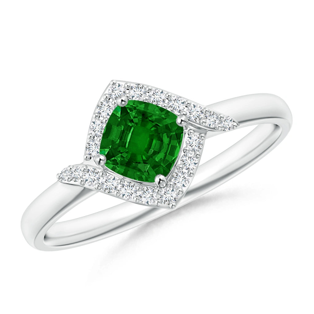 White metal ring with a cushion cut deep green stone in a square halo of tiny white stones