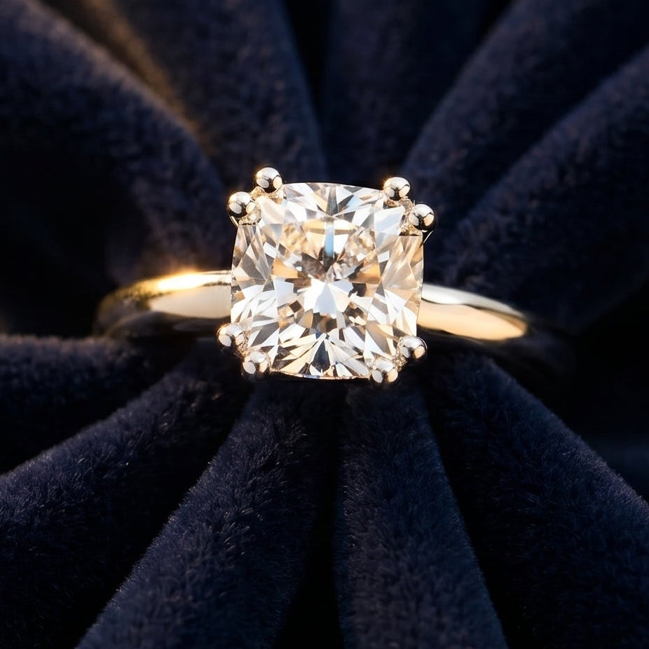 Gold ring with a large diamond on a dark blue fabric background