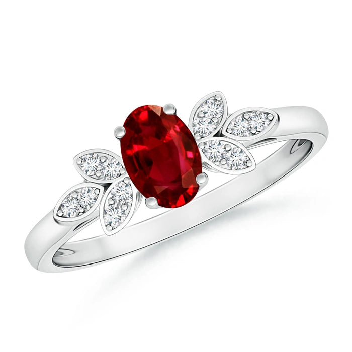 White metal ring with an oval ruby inside petals of small round diamonds in a flower motif