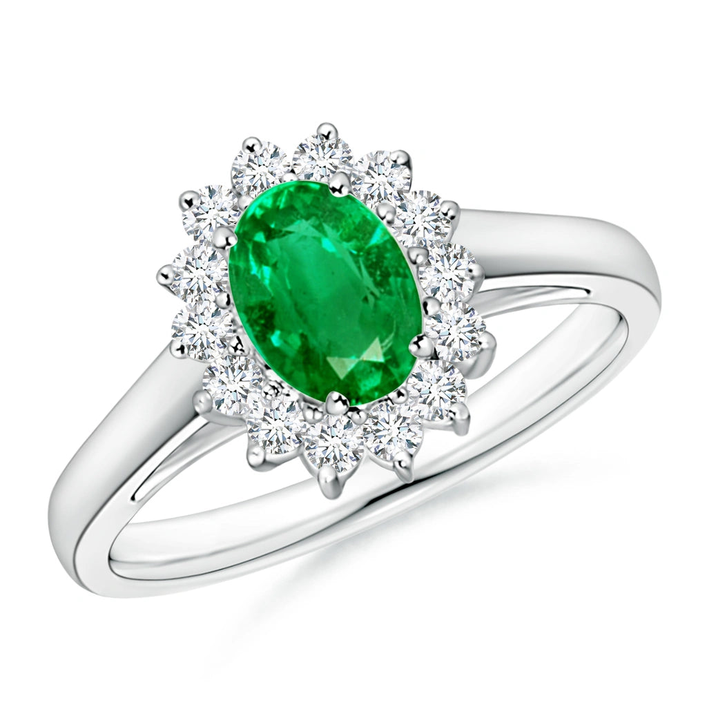 White metal ring with an oval green stone framed by a daisy cluster halo of round white stones