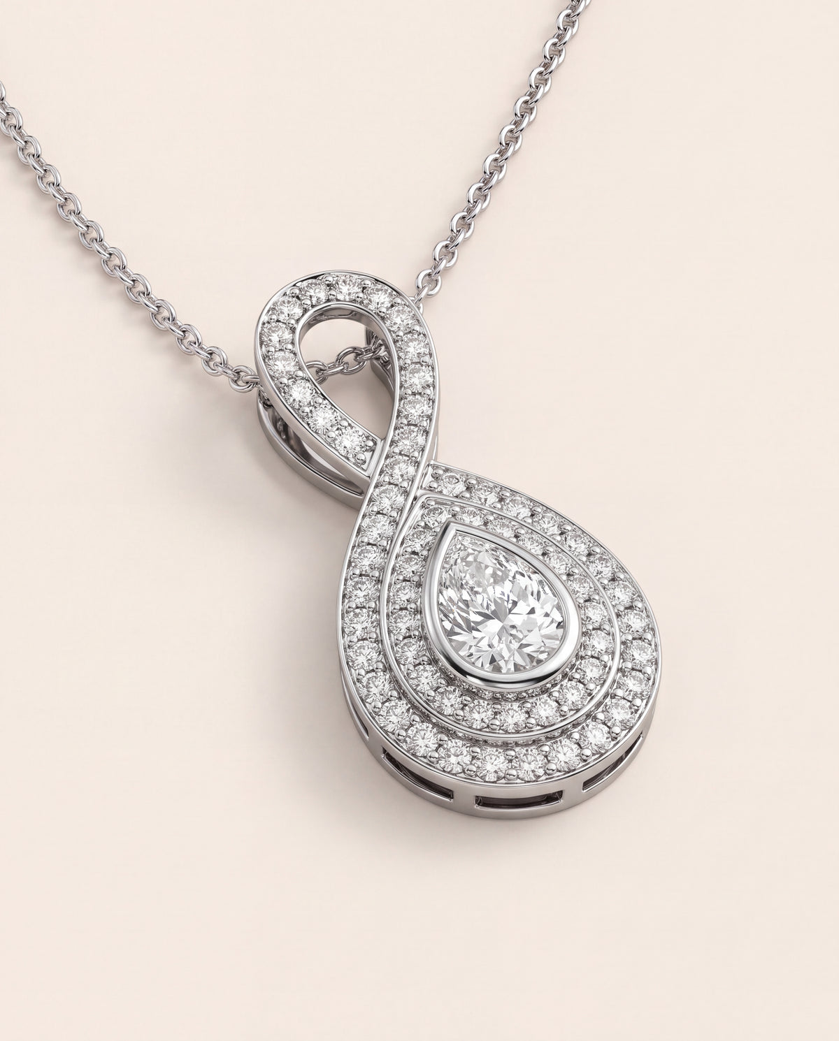 A pear diamond pendant in a double halo with a diamond-set looped bail, on a fine chain